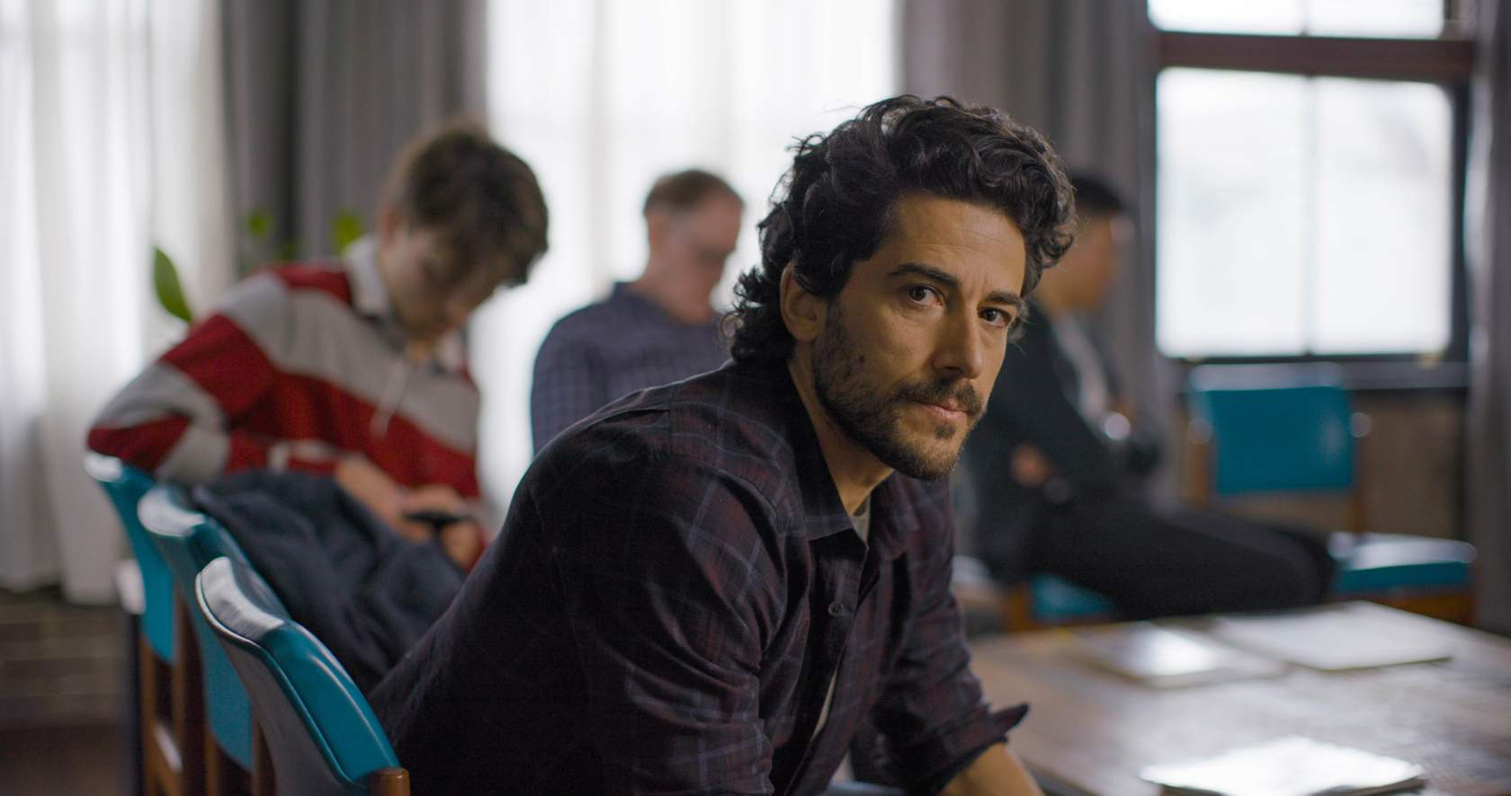 Man seated in a group session, looking toward the camera